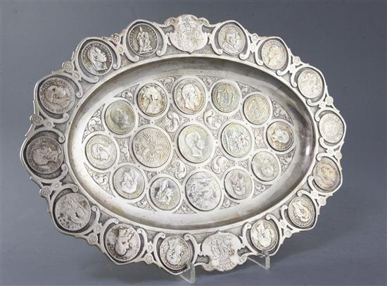 An early 20th century German 800 standard silver oval dish inset with numerous, mainly continental coins, gross 34 oz.